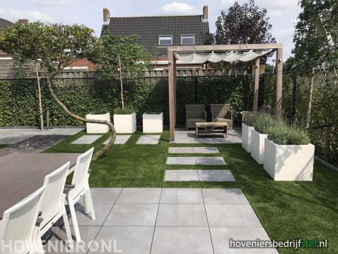 Moderne tuin met sierbestrating, kunstgras en houten pergola