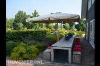 Groene tuin met houten tuinmeubels op terras