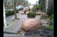 Onderhoudsarme voortuin met betontegels, grind en rotsblok