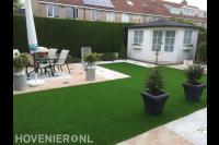 Achtertuin met kunstgras en terras