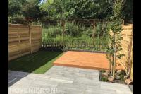 Achtertuin met bestrating van natuursteen, grasveldje en vlonder