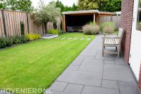 Achtertuin met gazon, houten schutting en overkapping