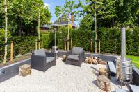 Zitkuil met grind omgeven door verhoogde borders met leibomen