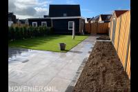 Tuinaanleg met bestrating van siertegels, gazon en houten schutting 2