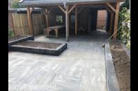 Tuinaanleg met overkapping, bestrating en plantenbakken