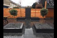 Tuinaanleg met bestrating van natuursteen en plantenbakken