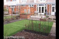 Achtertuin met gazon en terrasoverkapping