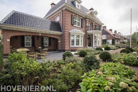 Klassieke villatuin met hortensia's en buxusbollen