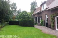 Boerderijtuin met gazon en bestrating van waaltjes