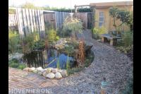 Tuin met kleine vijver, grindpad en schuurtje