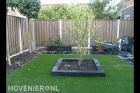 Tuinaanleg met bestrating, kunstgras en plantenbakken