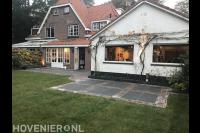 Tuin met gazon van graszoden en terras van siertegels en klinkers