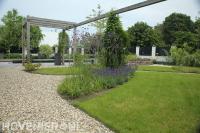 Landelijke tuin met gazon, pergola en grindpaden