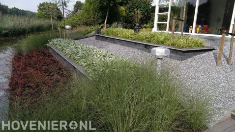 Onderhoudsarme tuin met siergrassen en split aan het water