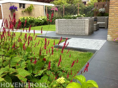 Achtertuin met terras, gazon en kleurrijke beplanting