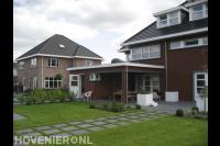 Achtertuin met terras van antraciet tegels en gazon met stapstenen