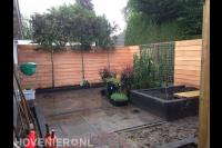 Tuinaanleg met bestrating, schutting, plantenbak en leibomen