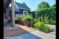 Compacte tuin met cortenstaal element, overkapping en terras