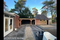 Tuinaanleg met sierbestrating en houten overkapping