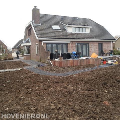 Voorbereidend grondwerk in tuin bij villa met verhoogd terras