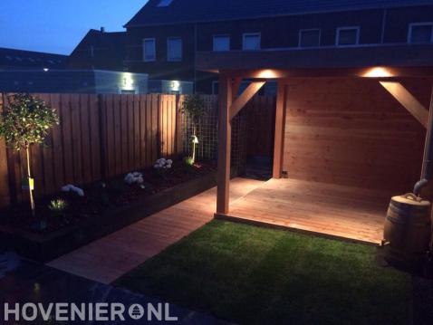 Buitenverlichting in tuin met houten overkapping en gazon