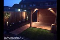 Buitenverlichting in tuin met houten overkapping en gazon