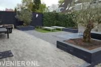 Tuinaanleg met bestrating en plantenbakken met olijfbomen