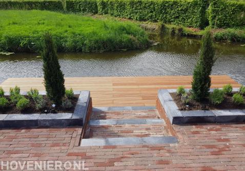 Tuin aan het water met houten vlonder