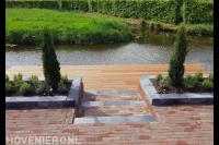 Tuin aan het water met houten vlonder