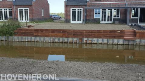 Houten beschoeiing bij tuin aan het water