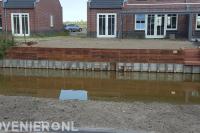 Houten beschoeiing bij tuin aan het water