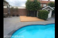 Houten vlonder en bestrating in tuin met zwembad