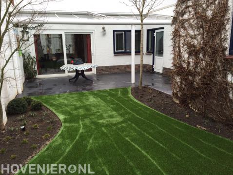 Achtertuin met terrasoverkapping en kunstgras