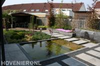 Strakke vijver met watermuur en stapstenen