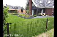 Achtertuin met plantenbakken en groot gazon