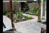 Tuin met terras, bestrating en borders met veel groen