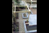 Strakke tuin met houten pergola en vijver