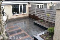 Achtertuin met sierbestrating en plantenbakken