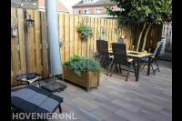 Achtertuin met sierbestrating en houten schutting