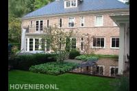 Vlonderterras en gazon bij statige villa