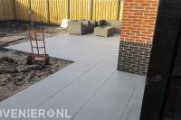 Tuinaanleg met keramische tegels en hout beton schutting
