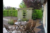 Houten tuinhuis en terras met tuinmeubels