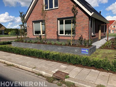 Voortuin met plantenbak van stapelstenen