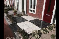 Voortuin met sierbestrating en nieuwe beplanting in borders