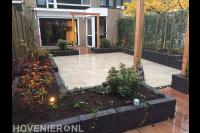 Achtertuin met keramische tegels, plantenbakken en houten pergola's