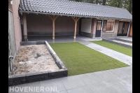 Tuinaanleg met keramische tegels, kunstgras en plantenbakken
