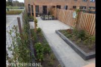 Achtertuin met bestrating en plantenbakken