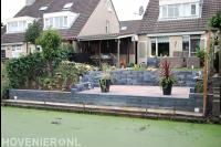 Tuin met hoogteverschillen en terras aan het water