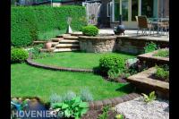 Tuinaanleg met gazon en trappetje naar verhoogd terras