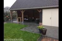 Houten overkapping aan schuur met bestrating van natuursteen 2